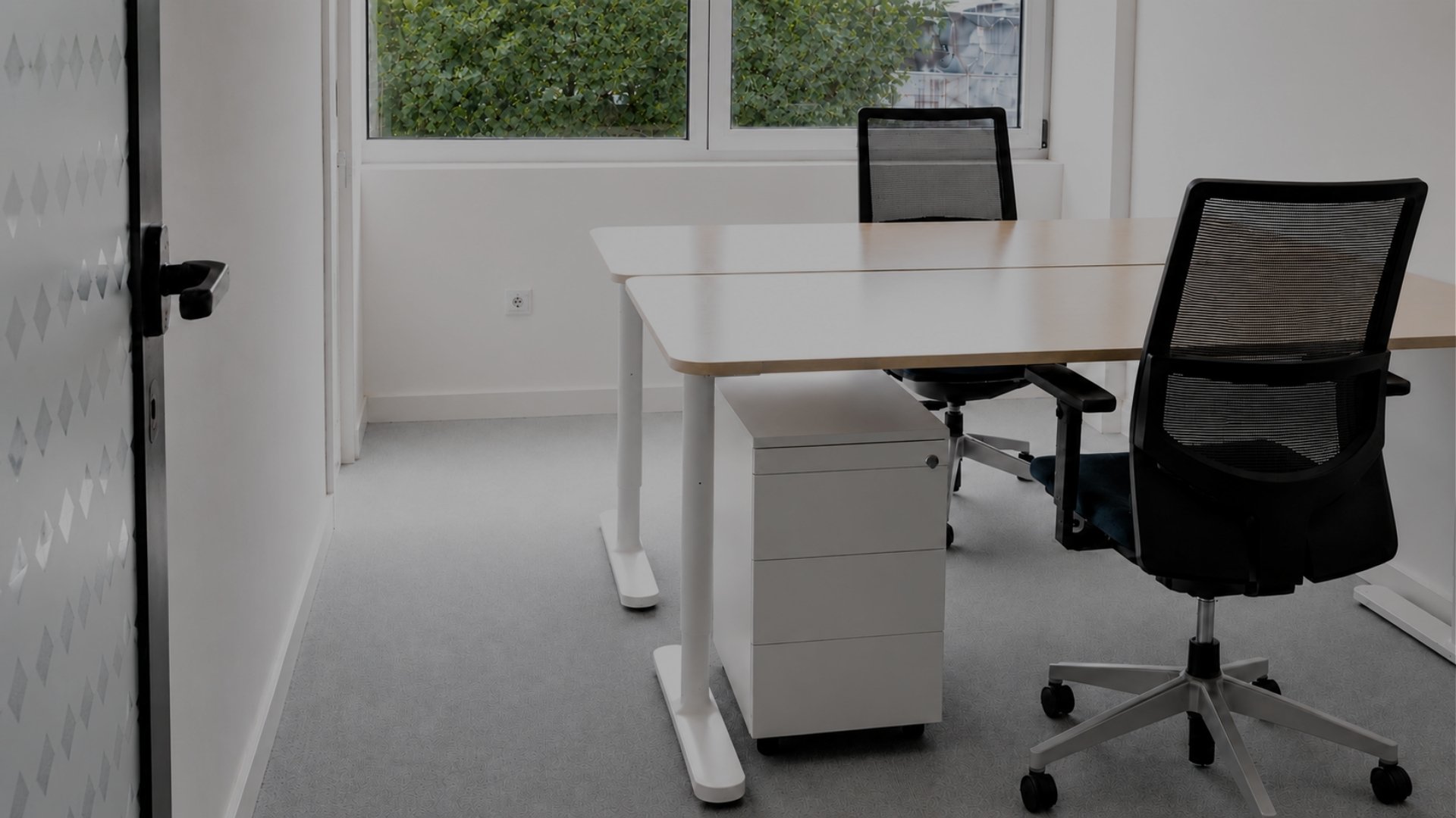 Gabinete privado da MaiSpace na Maia com duas secretárias, duas cadeiras ergonómicas e vista para o exterior.