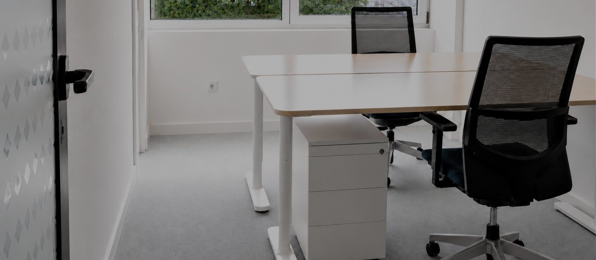 Gabinete privado da MaiSpace na Maia com duas secretárias, duas cadeiras ergonómicas e vista para o exterior.